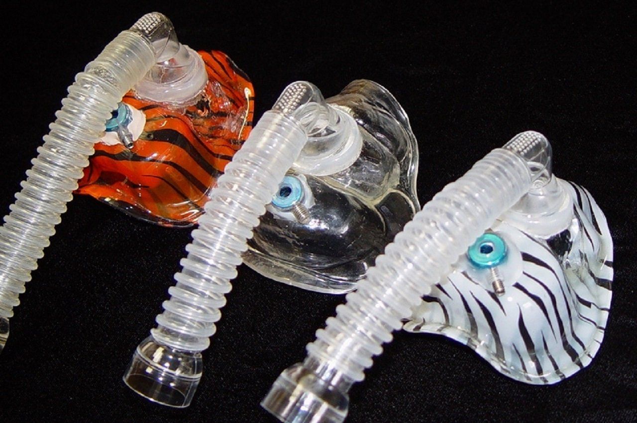 Three different custom design sleep apnea masks displayed on black background.